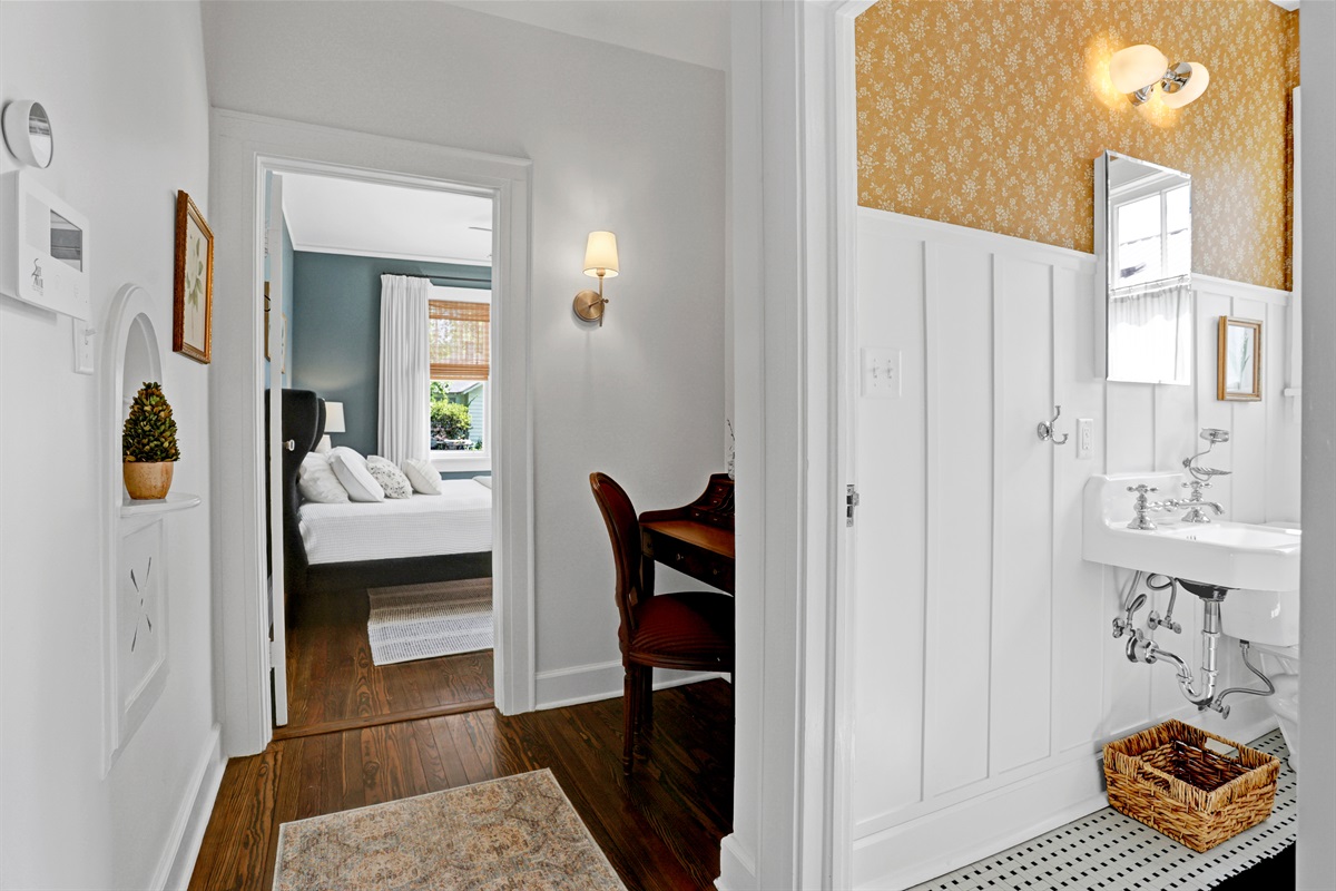 The sunny yellow wallpaper brings a lively, cheerful vibe to this beautifully updated hallway bathroom.