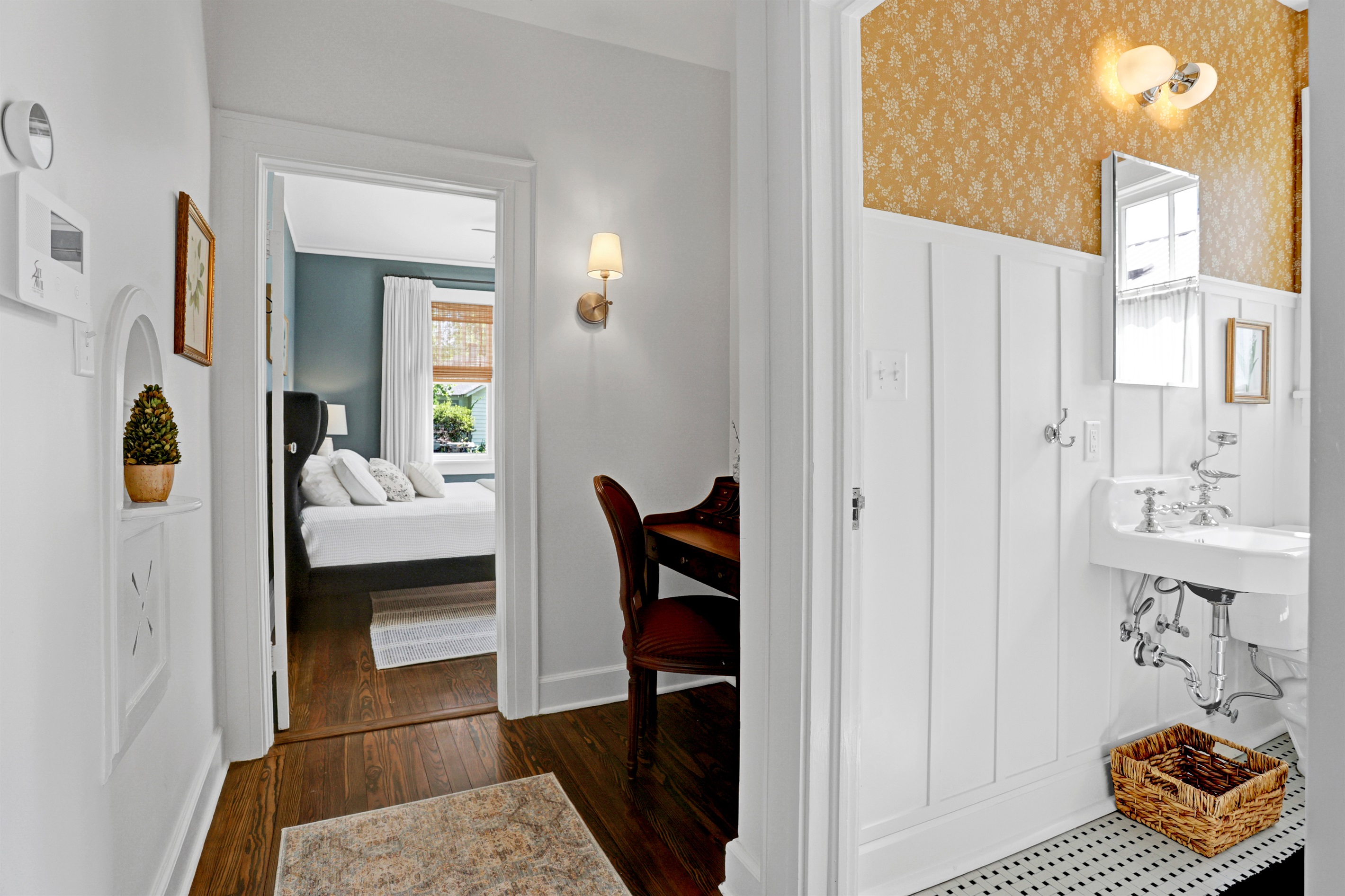 The sunny yellow wallpaper brings a lively, cheerful vibe to this beautifully updated hallway bathroom.