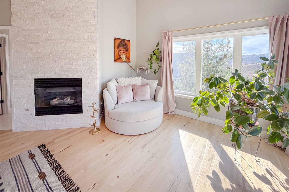 The luxurious master bedroom with charming corner loveseat creating the perfect spot to curl up with a book or morning coffee enjoying the sunshine and views.