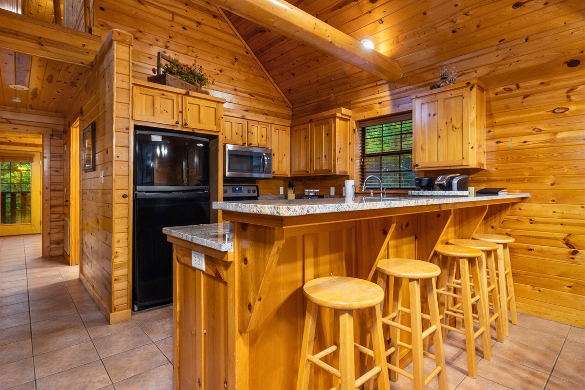 A warm, wood-filled kitchen with bar seating makes meals and memories easy. Cook, gather, and enjoy time together.