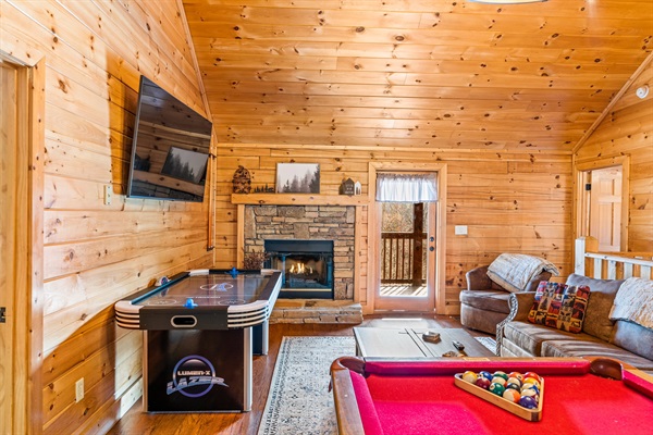 Upstairs loft game room with pool table, air hockey, arcade game, and big screen TV