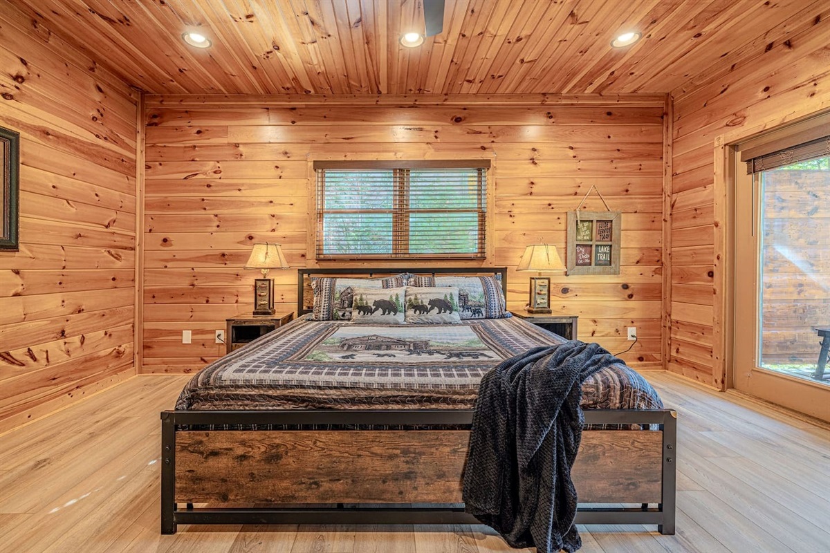 Lower-level king bedroom with private en-suite bath and deck access. The Crown Jewel &mdash; 5BR/5BA luxury cabin in Gatlinburg, TN. Sleeps 12.