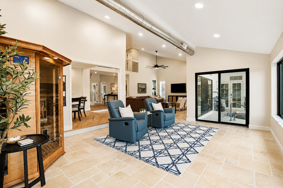 Bright, open-concept living space with high ceilings, modern seating, and seamless flow between indoor and outdoor areas. Stylish, airy design perfect for relaxing, entertaining, and enjoying group stays.