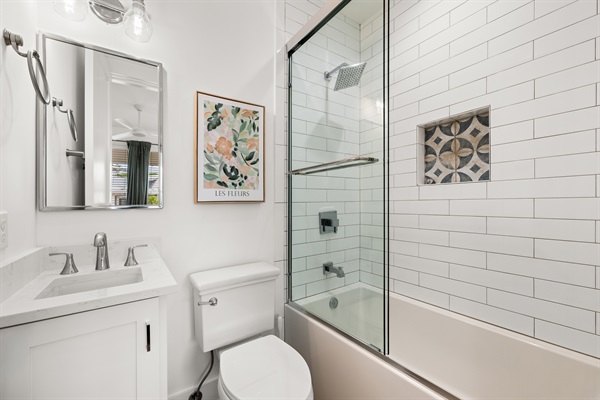 This private bathroom features bright finishes and a clean coastal design, offering both comfort and convenience.