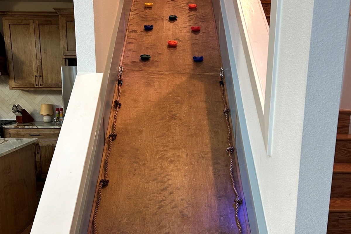 Unique indoor climb wall next to the staircase—an unforgettable feature kids love during their Broken Bow stay. 🌲🛝