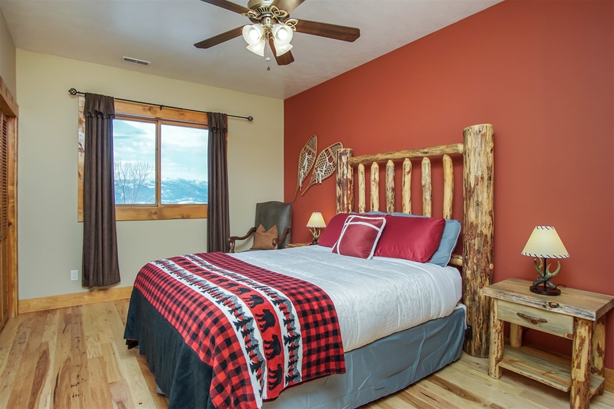 Inviting bedroom with queen bed, mountain views, and rustic decor