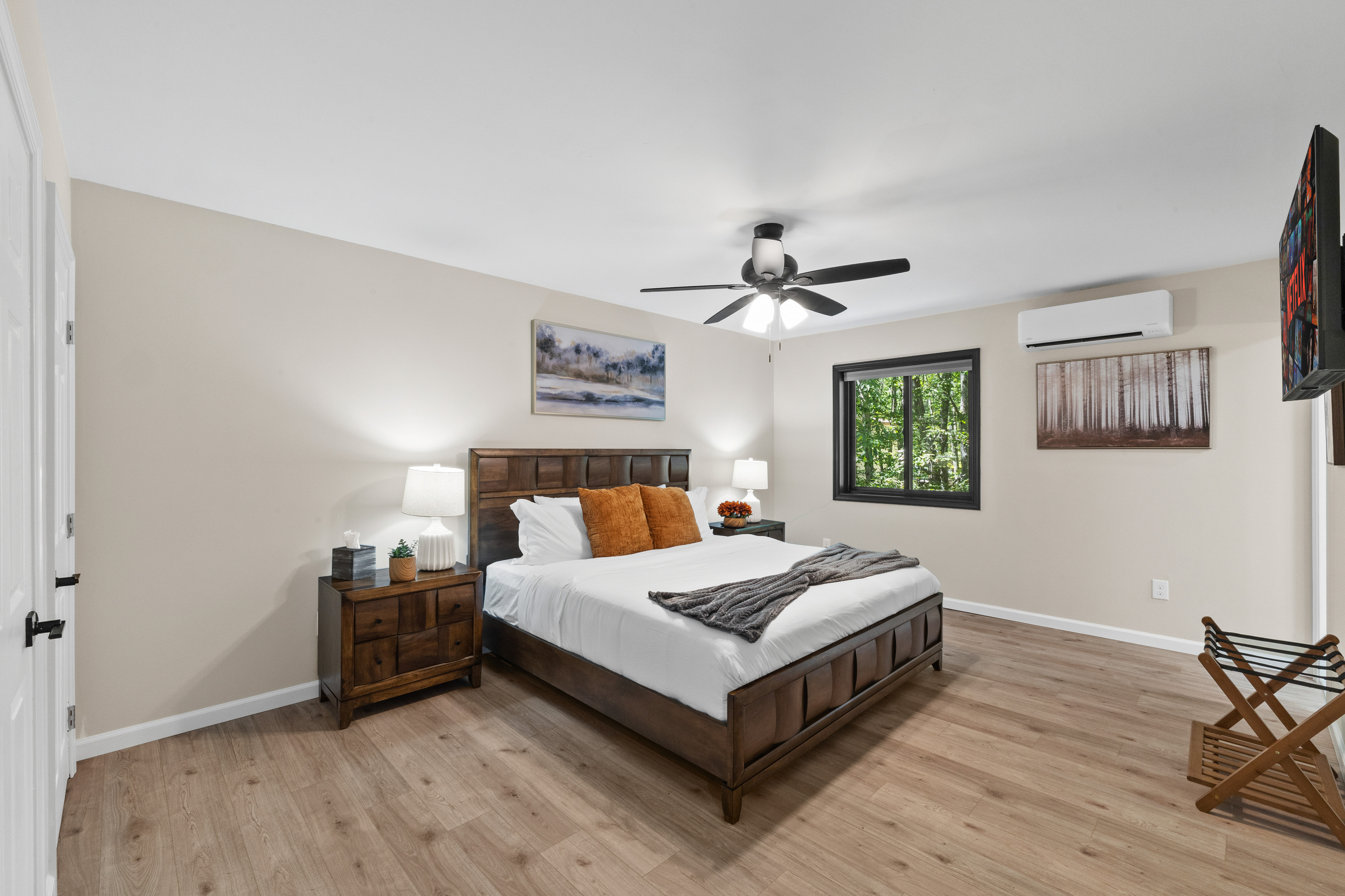 A warm, inviting bedroom features nature-themed artwork and a rich color palette
