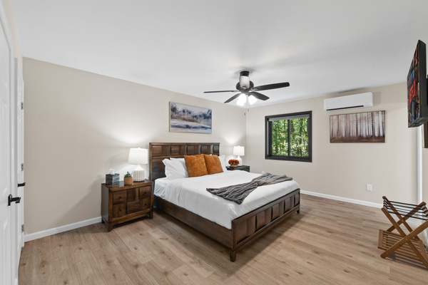 A warm, inviting bedroom features nature-themed artwork and a rich color palette