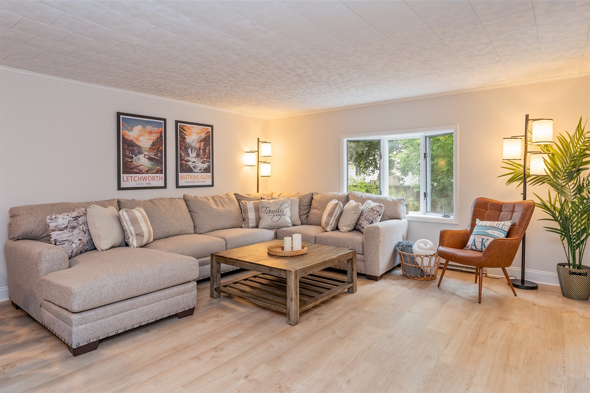 Unwind in this spacious living room featuring a plush fold out sectional, cozy leather chair, and natural light—perfect for relaxing after exploring the Finger Lakes!