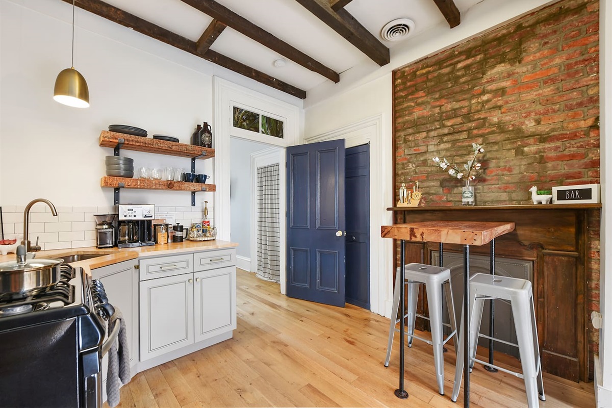 Enjoy a well-equipped kitchen with a sleek center table, a cozy brick wall accent, and modern appliances—plus a coffee maker to start your day right!