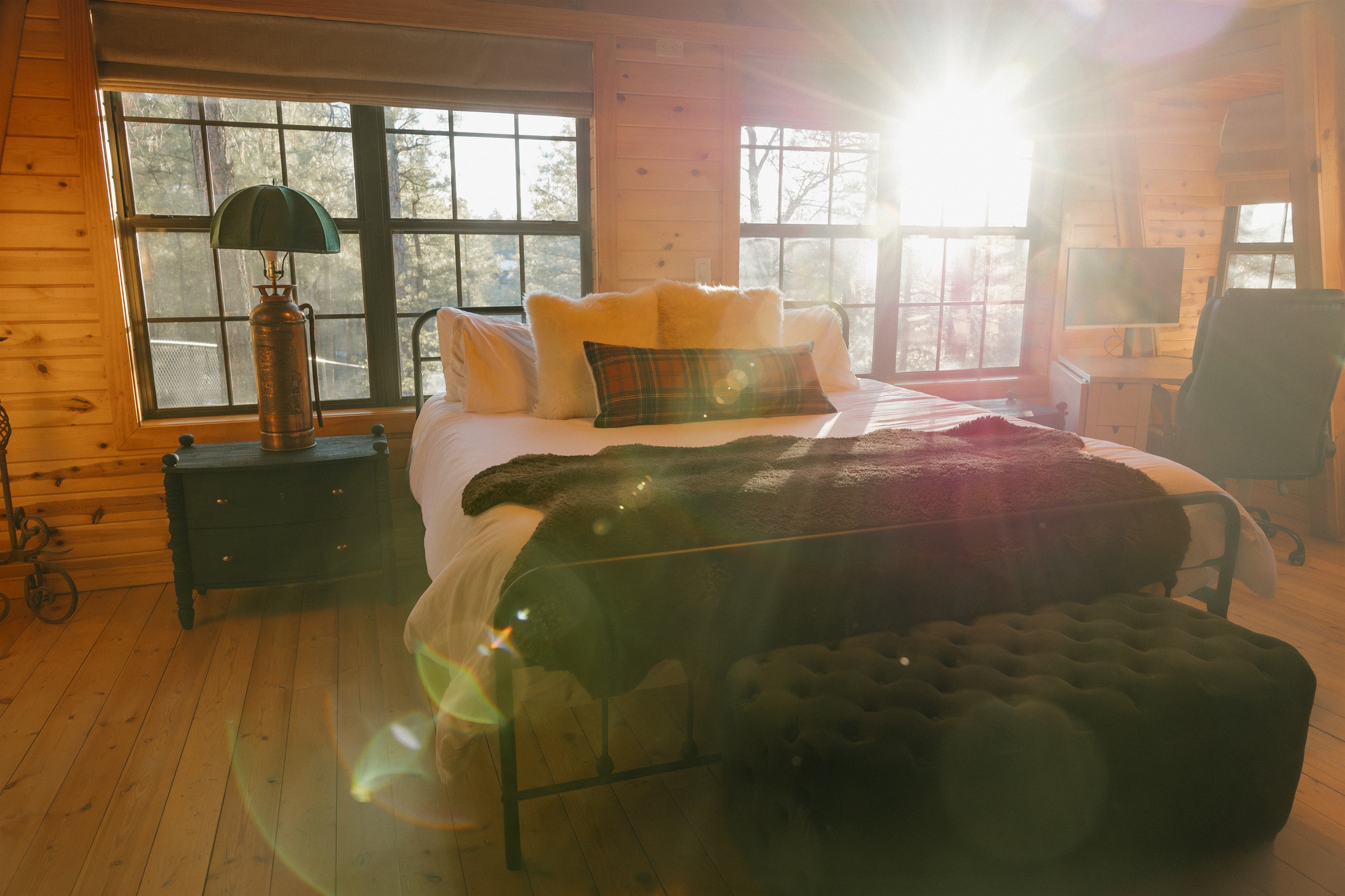 Wake to golden sunlight streaming through windows in the cozy bedroom at Poppywood Pines. This gothic western Show Low A-frame features plush bedding and rustic charm, perfect for restful nights after exploring White Mountains hiking trails and fishing.