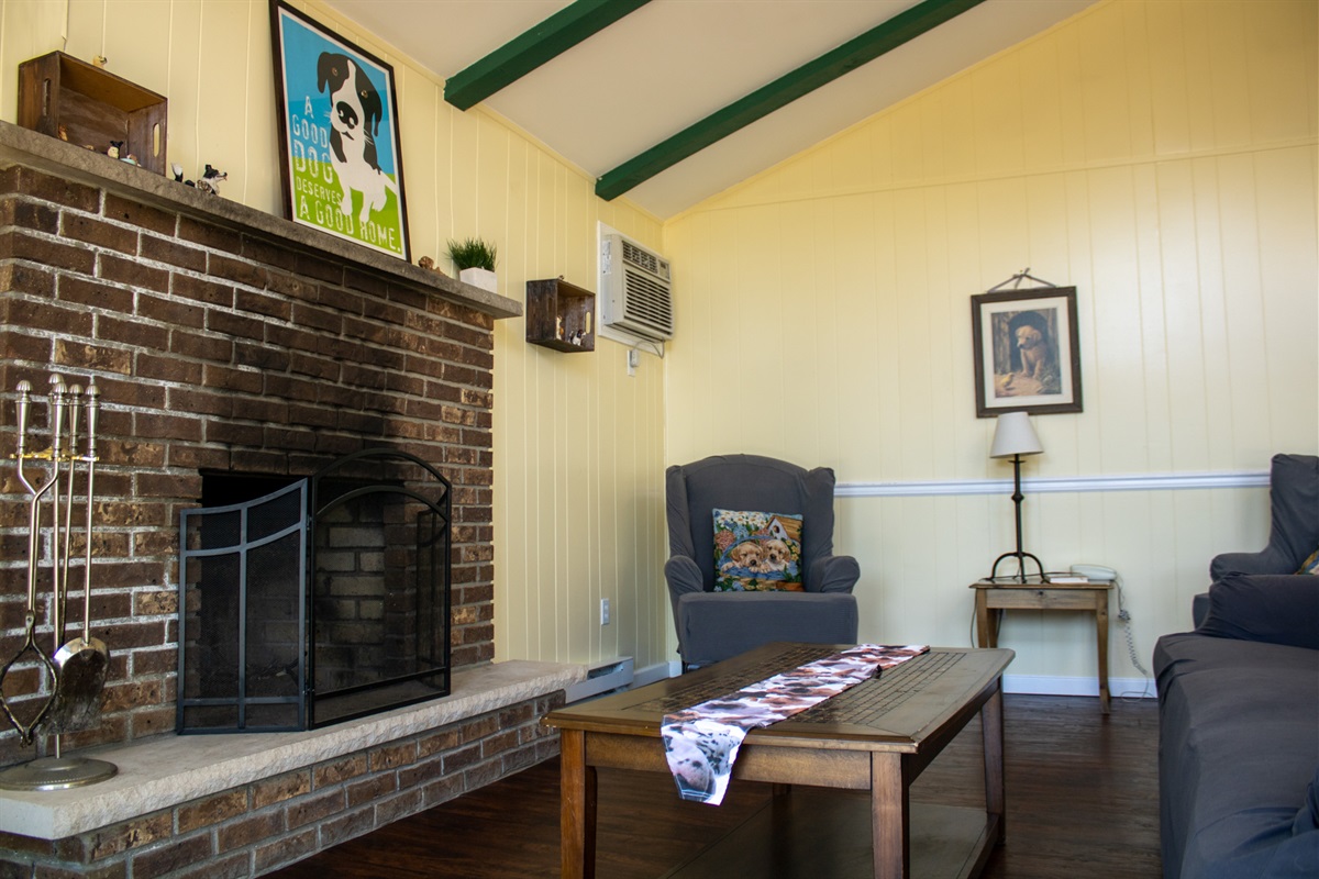 Open concept living room with cozy fireplace, gorgeous natural light spilling in from sliding glass doors leading to your private fenced in deck & yard.