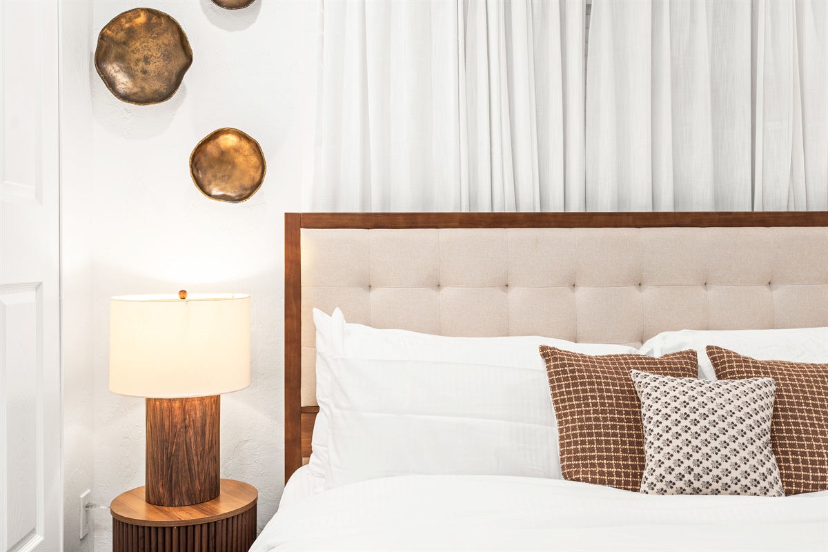 Soft neutrals, warm wood tones, and cloud-like bedding create the ultimate retreat.