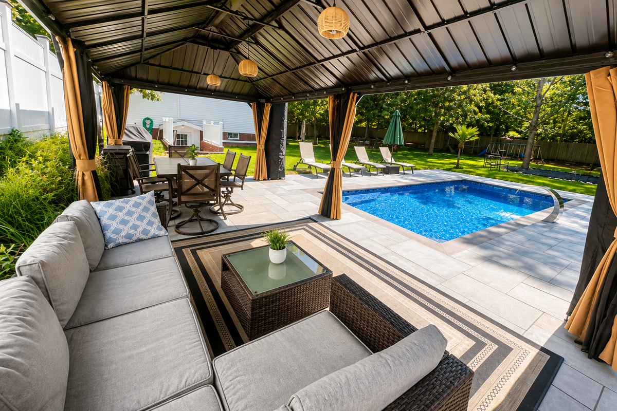 Covered outdoor lounge with plush seating overlooking the pool