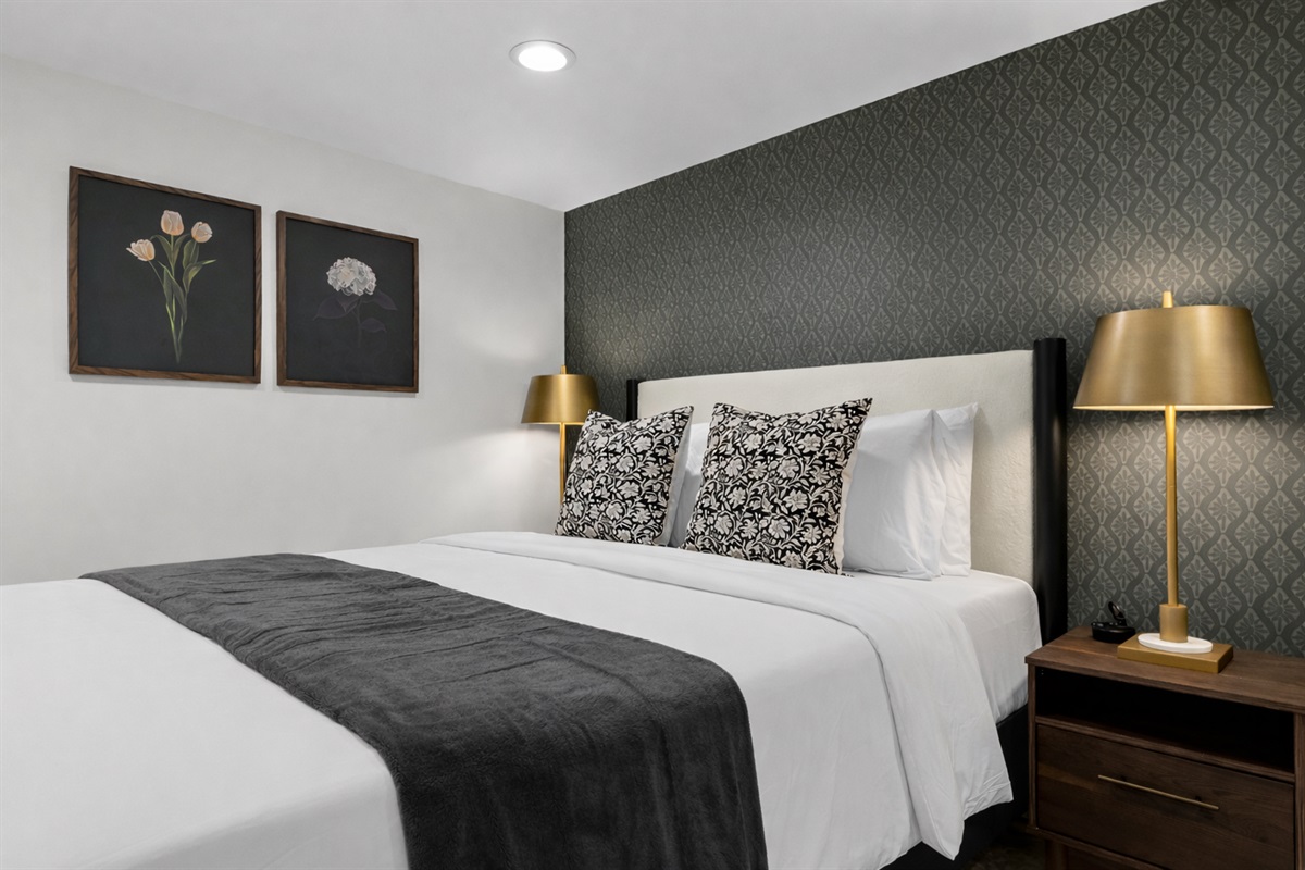 Relaxing bedroom space with a comfortable king bed, crisp linens, and warm accent lighting—designed for peaceful nights and a cozy, inviting stay.