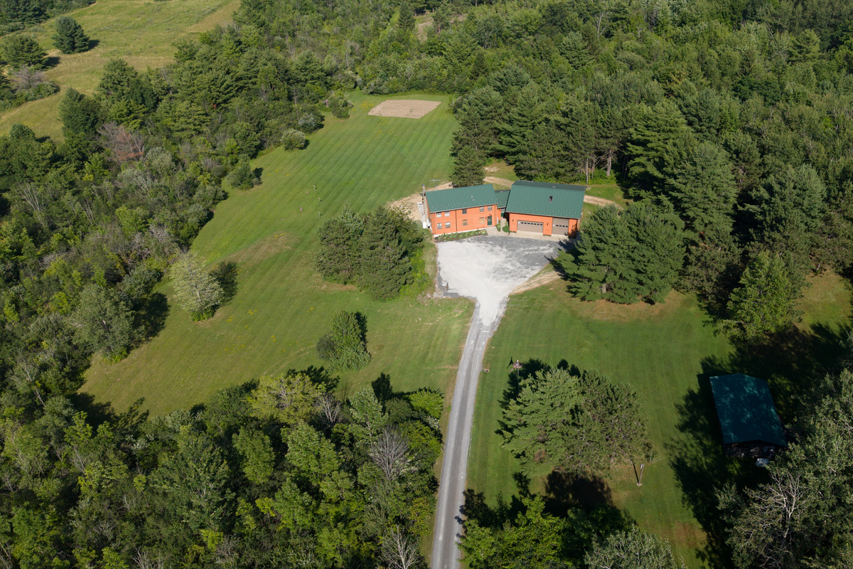 Aerial view of the home and long driveway