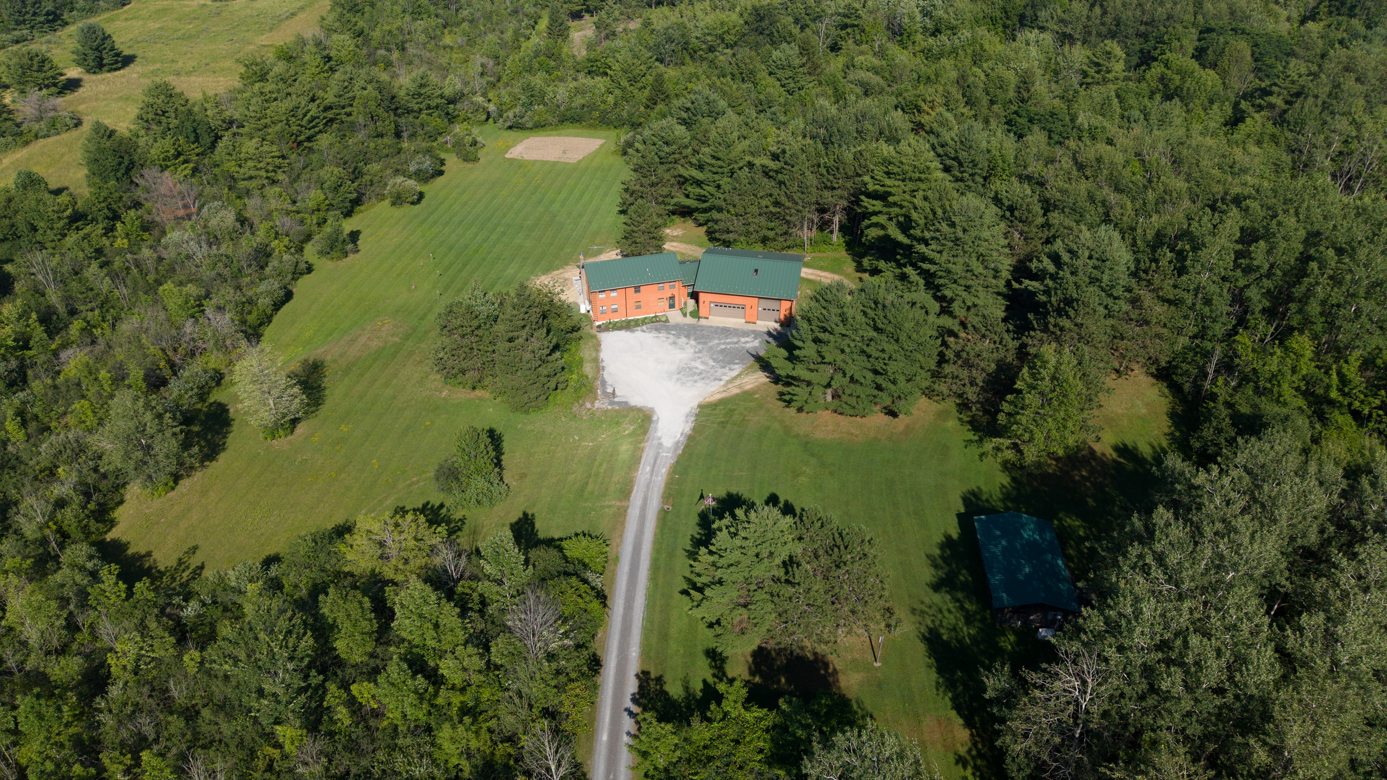 Aerial view of the home and long driveway
