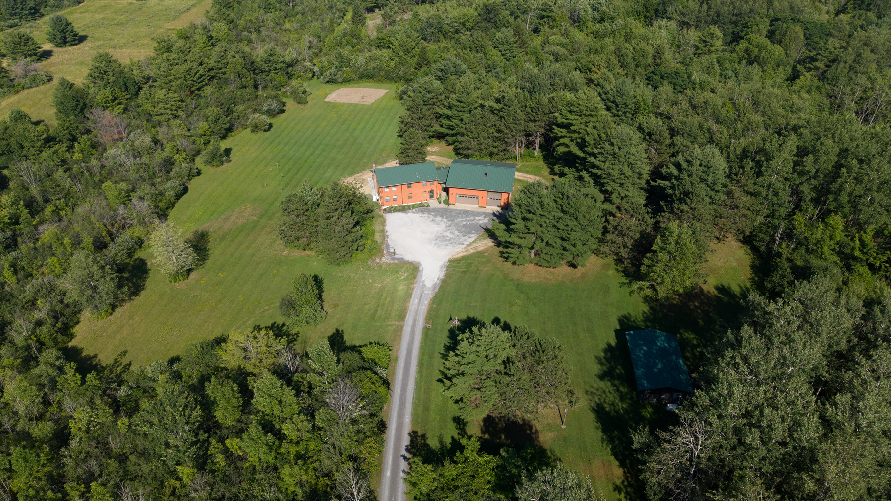 Aerial view of the home and long driveway
