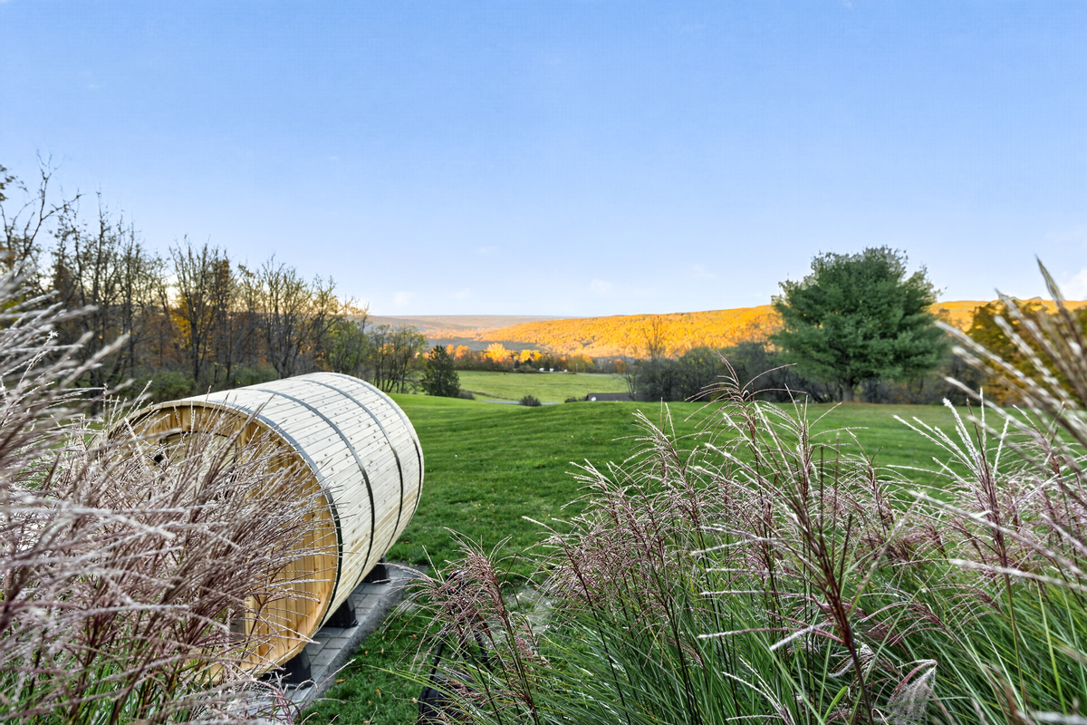 Barrel sauna overlooking the grassy yard