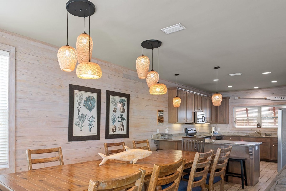 Dining area with a table and chairs set for 8 and additional seating for 4 at the breakfast bar 