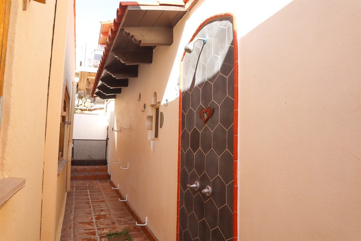 Upstairs outdoor shower and surfboard wall racks.