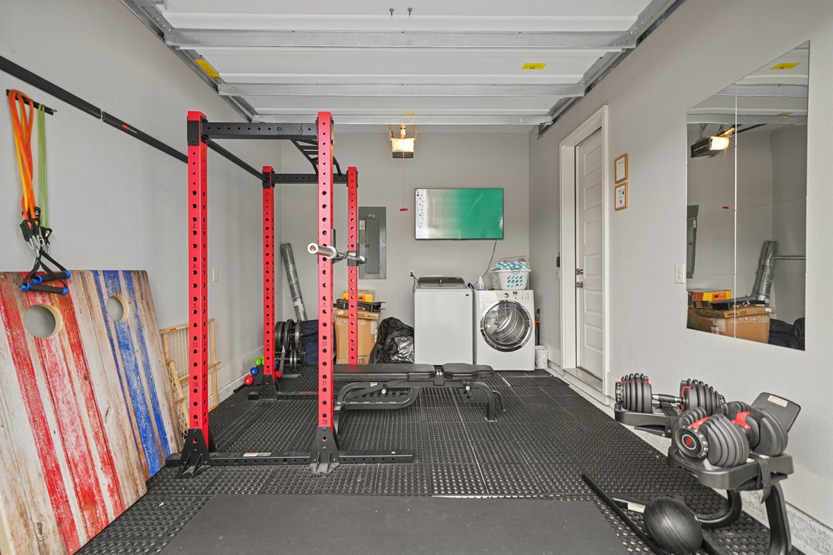 Private garage gym featuring a power rack, weights, and workout space.