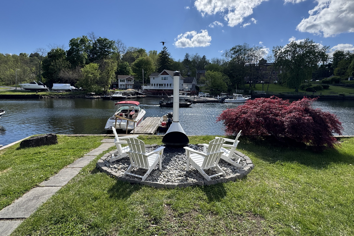 Gather around the iconic white chiminea beside the water