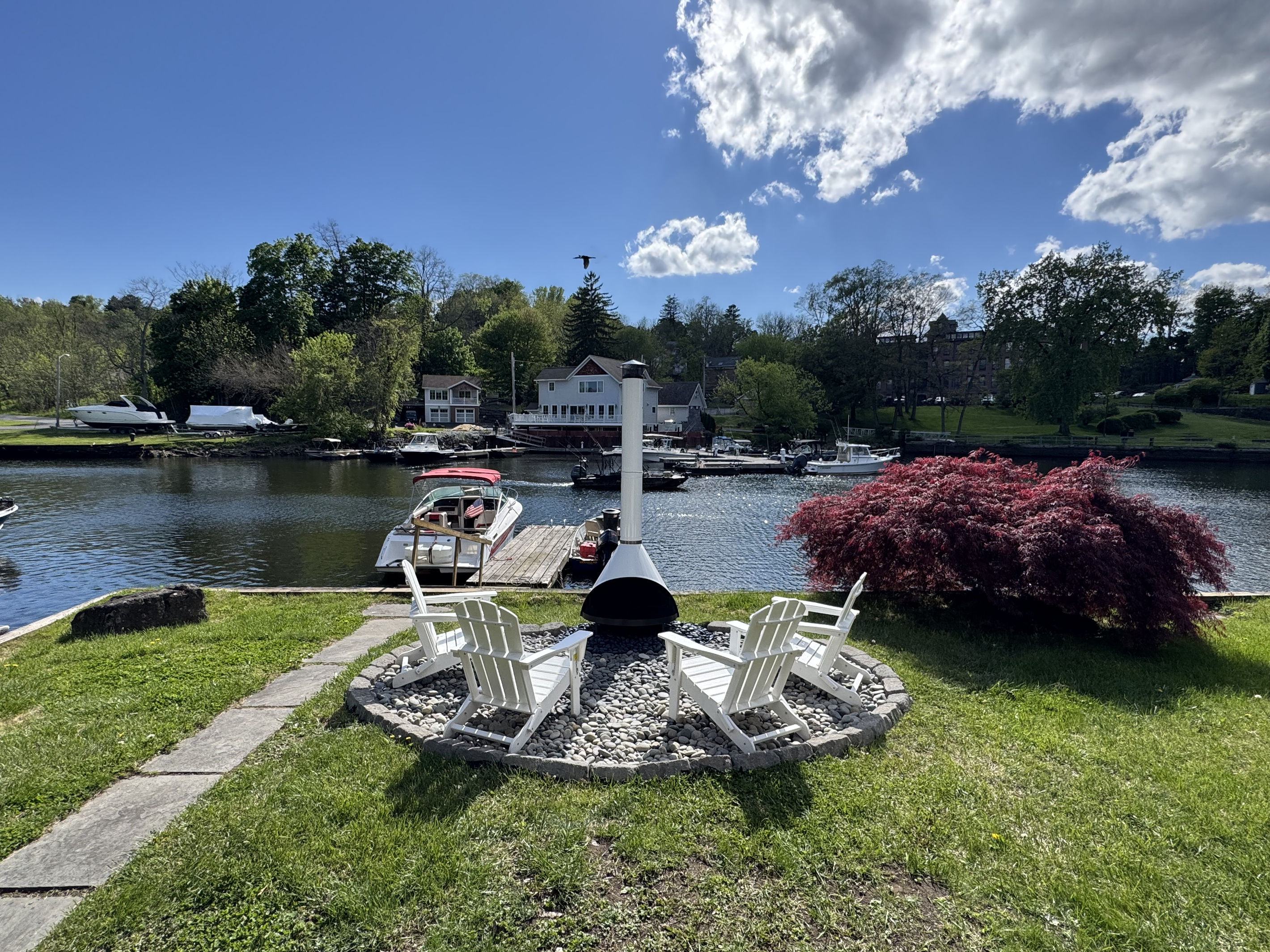 Gather around the iconic white chiminea beside the water