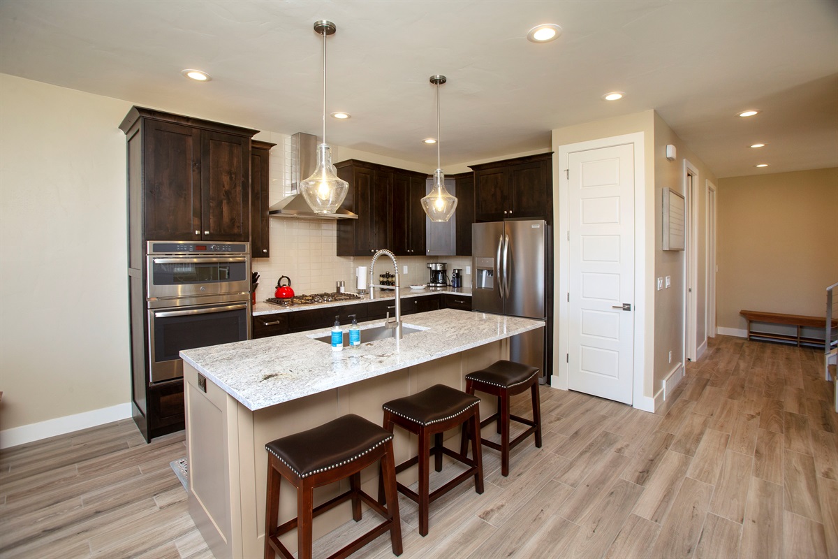 Modern kitchen featuring quartz countertops, stainless steel appliances, and ample space for meals together.