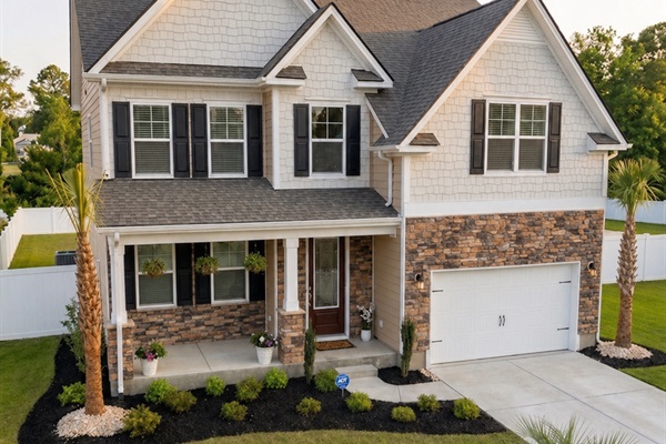 Exterior View: Stunning curb appeal with vibrant skies and lush greenery awaits your relaxation!