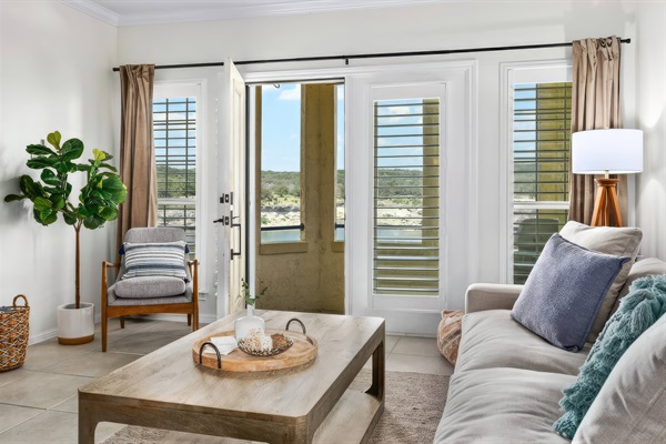 Bright living room with balcony access, comfortable seating, and peaceful Lake Travis views for a relaxing Lago Vista stay.