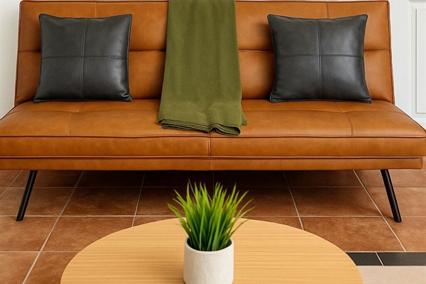 Cozy lounge with leather-style bench, greenery, and mid-century flair — a stylish corner for conversation. 