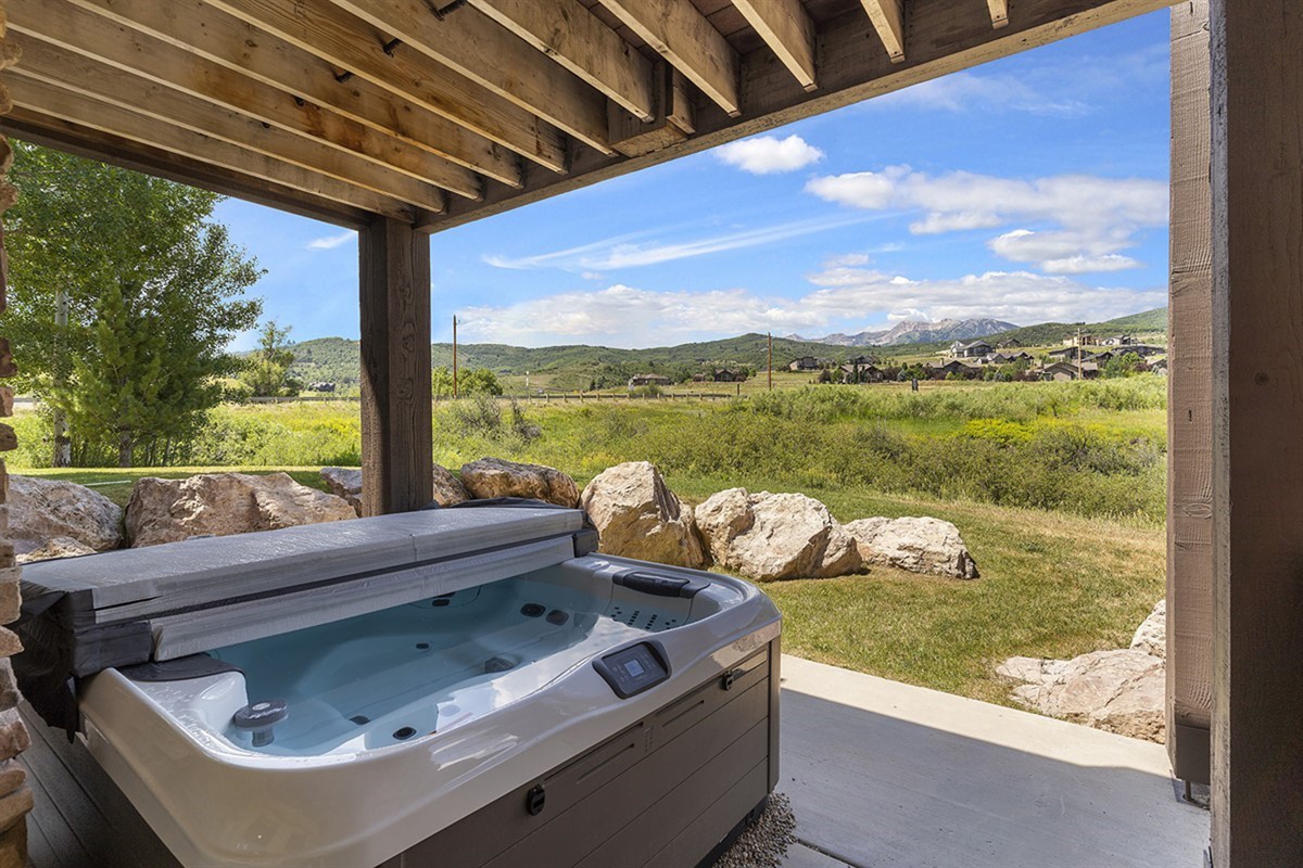 Indulge in your private outdoor retreat, where a soothing hot tub overlooks sweeping valley vistas—perfect for sunset soaks and serene, starlit evenings.