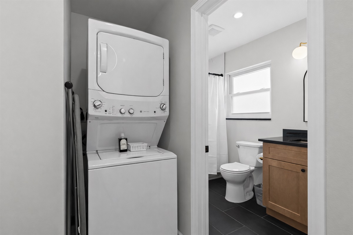 Convenient in-unit laundry tucked beside a modern bathroom—making longer stays easy, comfortable, and stress-free.