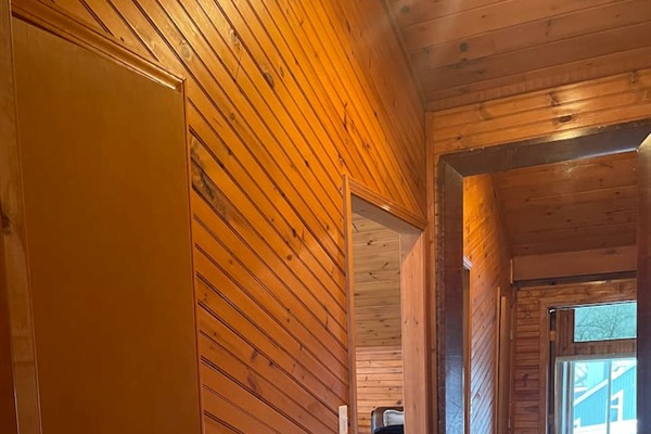 warm wood interior hallway with a large mirror connecting the cabin spaces.