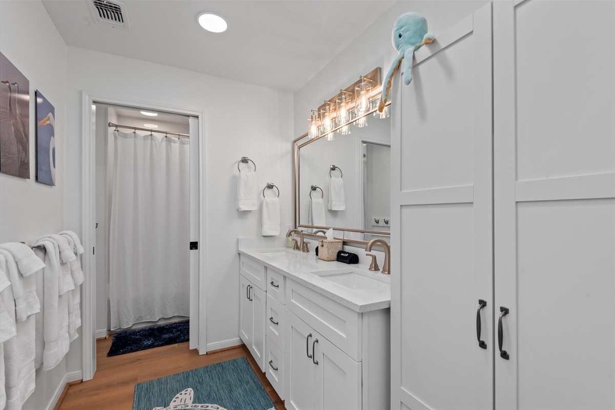 The bathroom offers double sinks and a spacious shower.