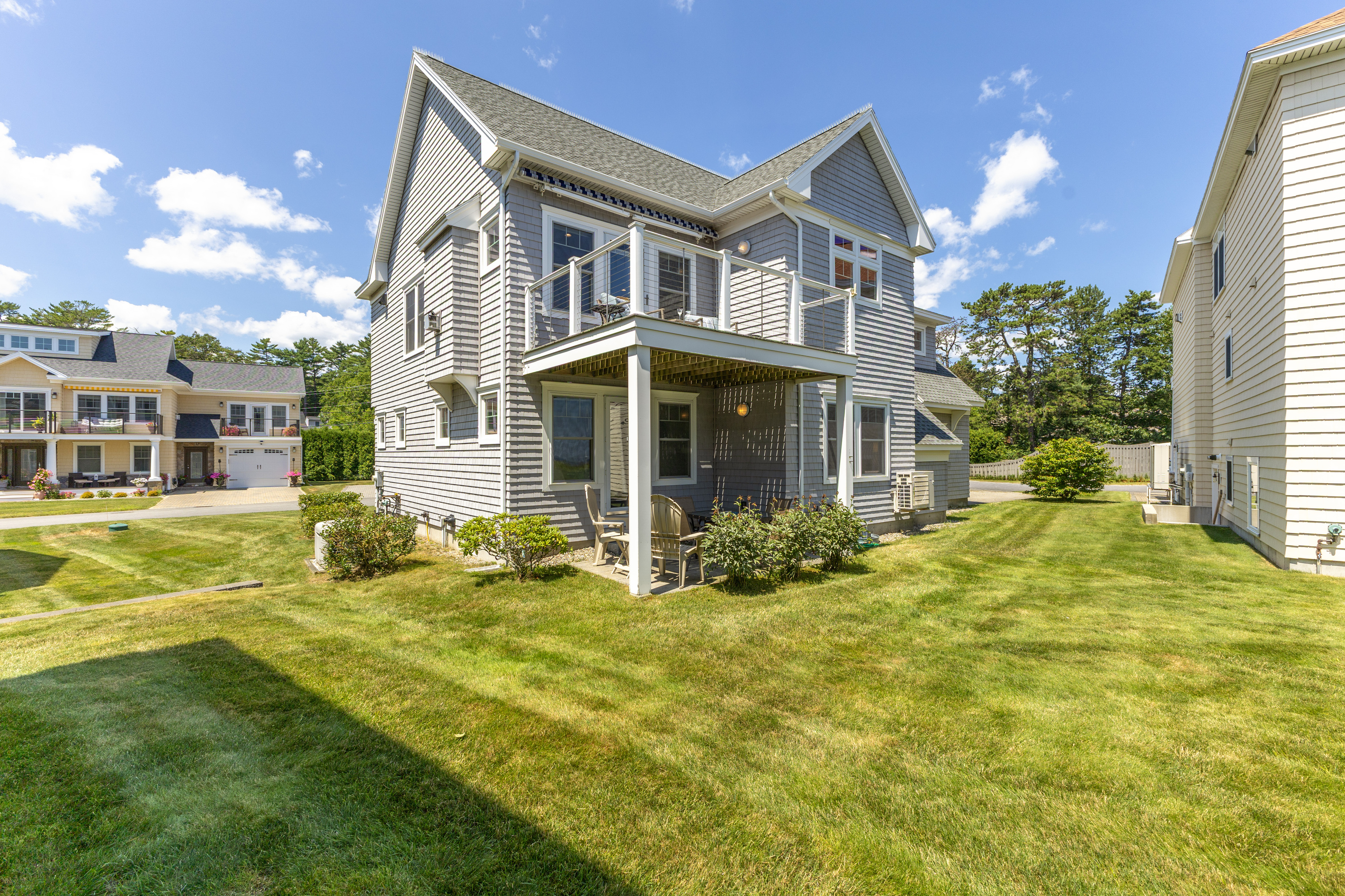 The backyard offers a grassy outdoor space to enjoy fresh coastal air just outside the home.