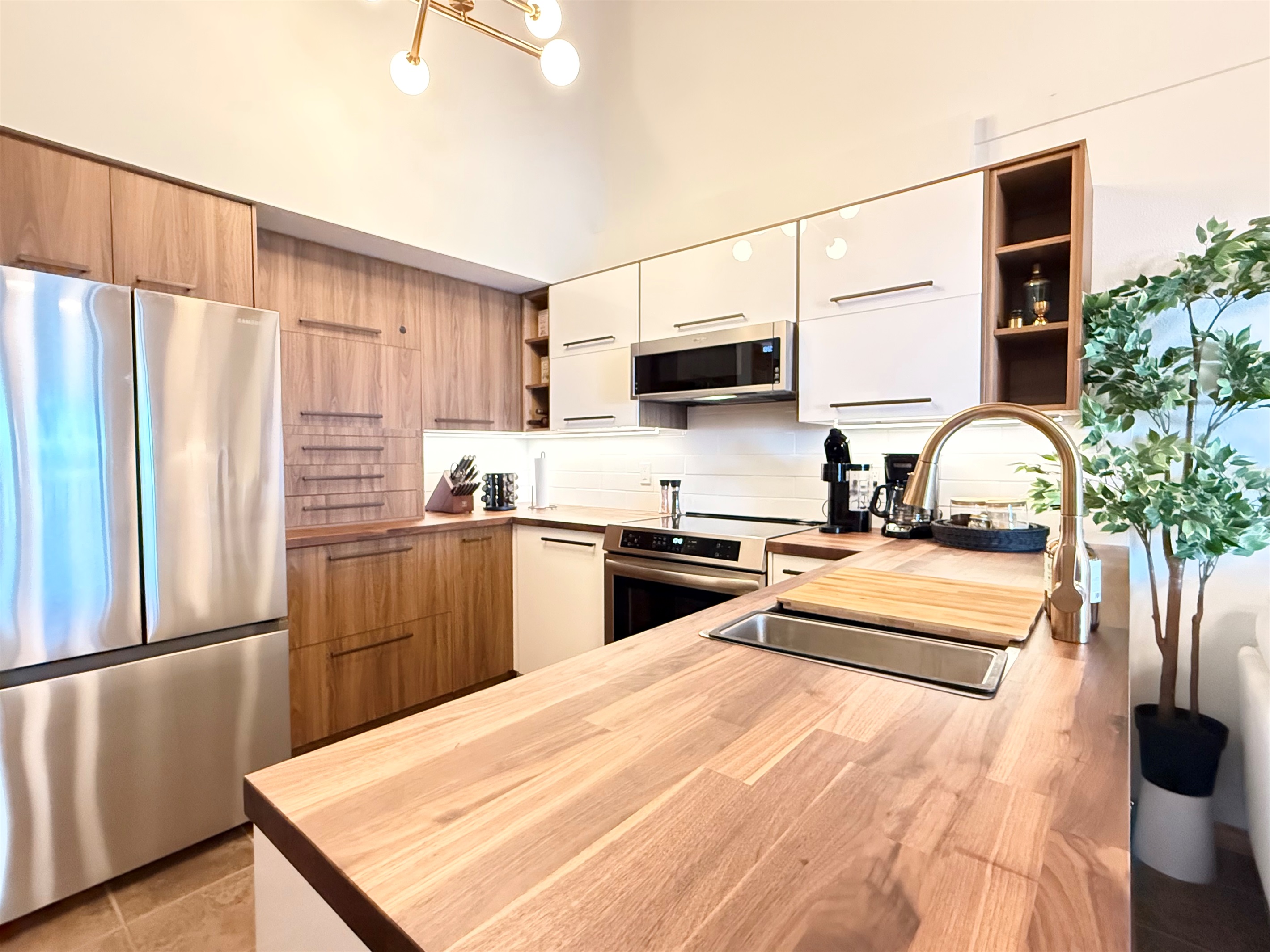 Ample Counter Space: This fully stocked kitchen provides plenty of counter space for meal preparation and a large wooden peninsula  perfect for gathering.