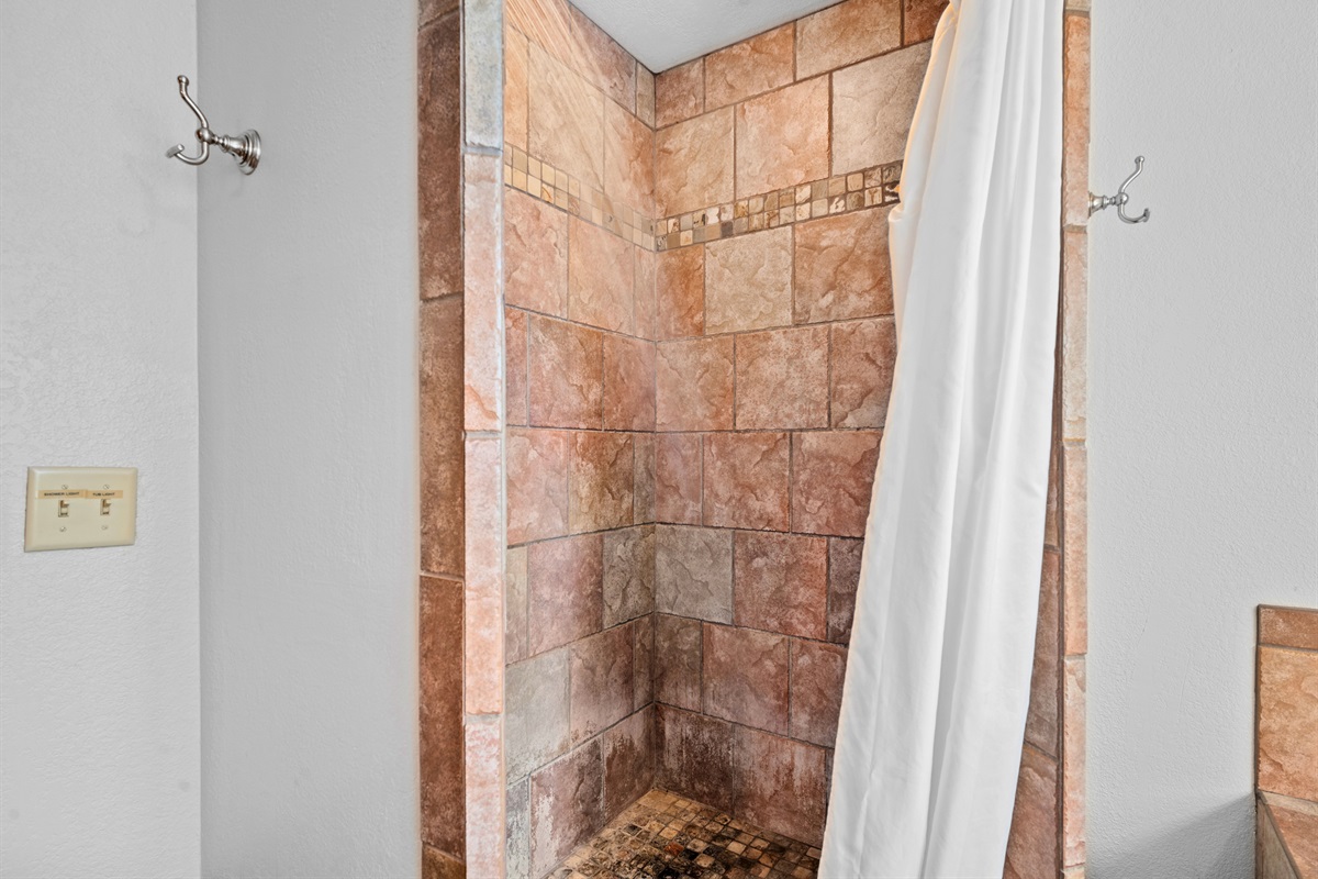 Modern tiled shower with soft lighting and plenty of space.