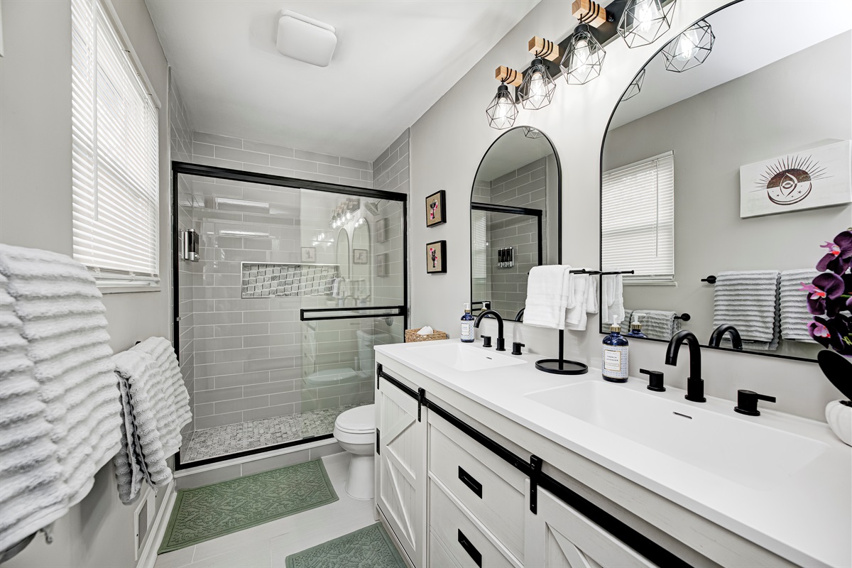 Fresh, modern bathroom with a spacious tiled shower and 2 sinks