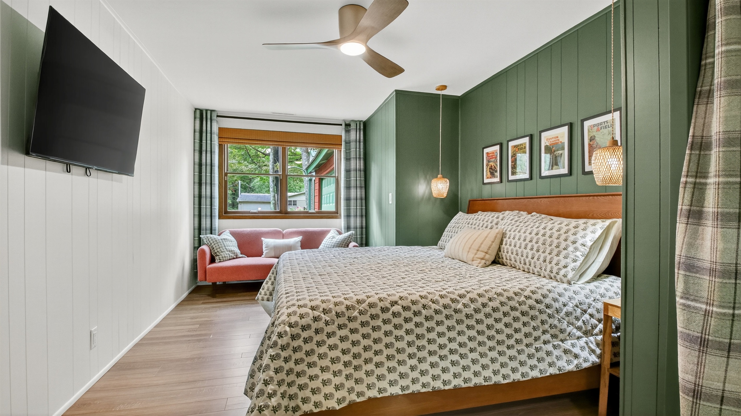 Spacious king bedroom with a Roku tv and cozy couch. This bedroom has a desk and office chair.