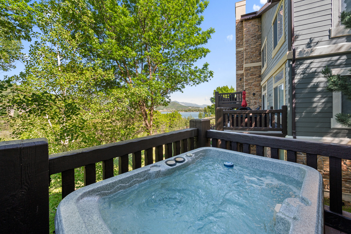 Relax in the bubbling private hot tub while enjoying serene lake views and the beauty of the surrounding mountains and trees.