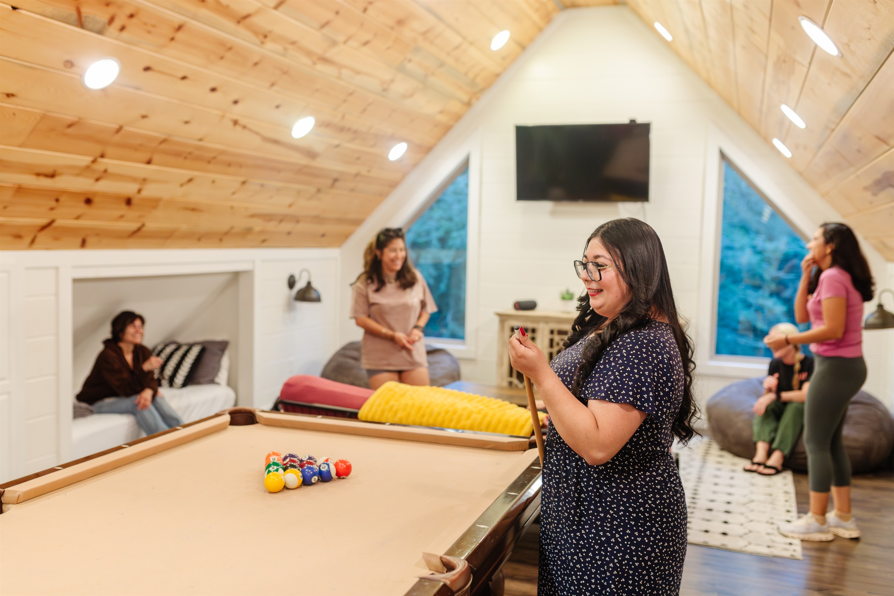 Spacious game loft with 4 twin beds—perfect for lounging, gaming & relaxing. Beds can be rolled out of knooks. Futon has been replaced with a sectional couch.