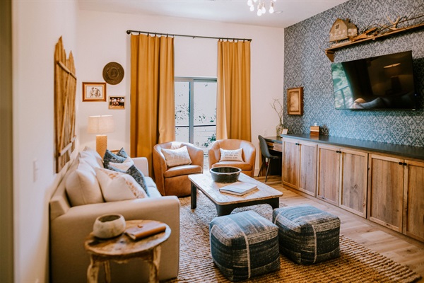 Cutter's Quarters living room &mdash; a shared lounge with smart TV and curated modern Western seating where your group gathers, included in your Gaines Ranch on the Square entire property reservation.