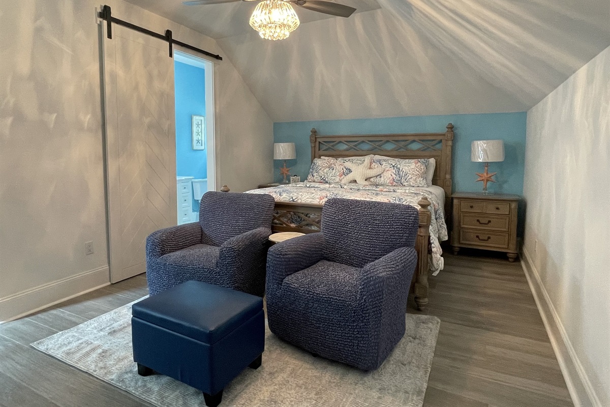 "Starfish Wishes" king bedroom w/sitting area. Barn door leads to ensuite bath