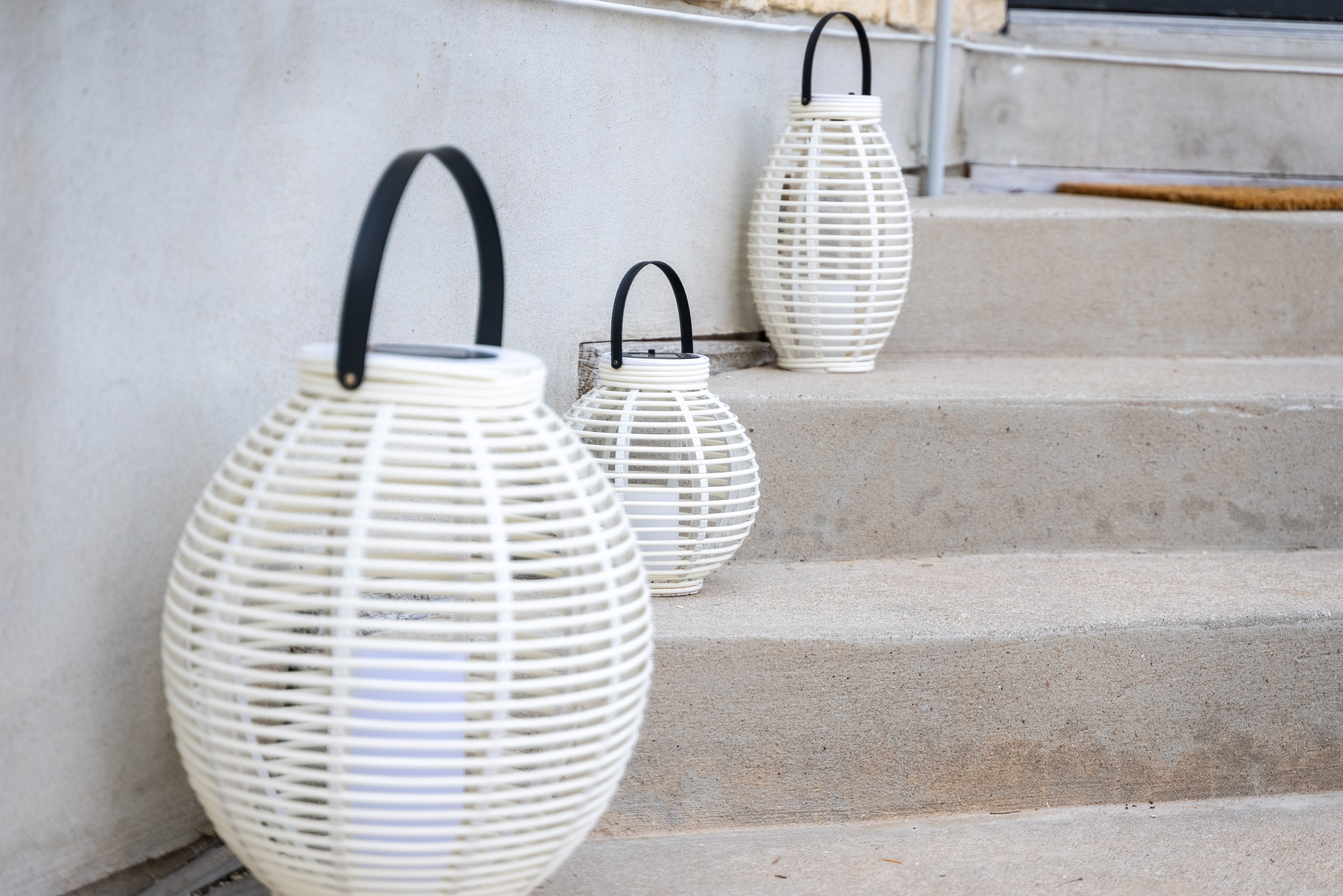 Globe lanterns light the way up a chic, textured stairway.