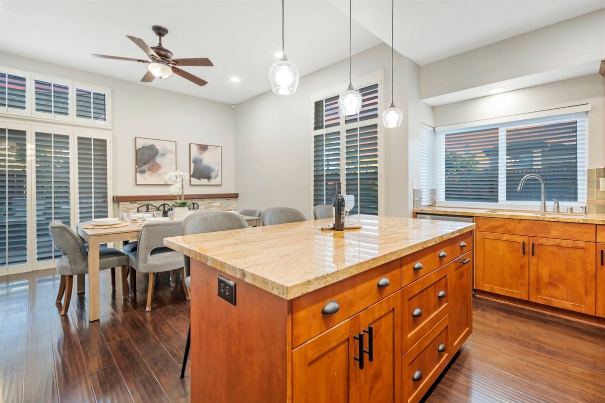 The kitchen features an open layout, seamlessly connecting to the dining room. The stylish bar stools provides extra seating, while large windows allow natural light. The kitchen’s modern design complements the dining room's elegant table & chairs.