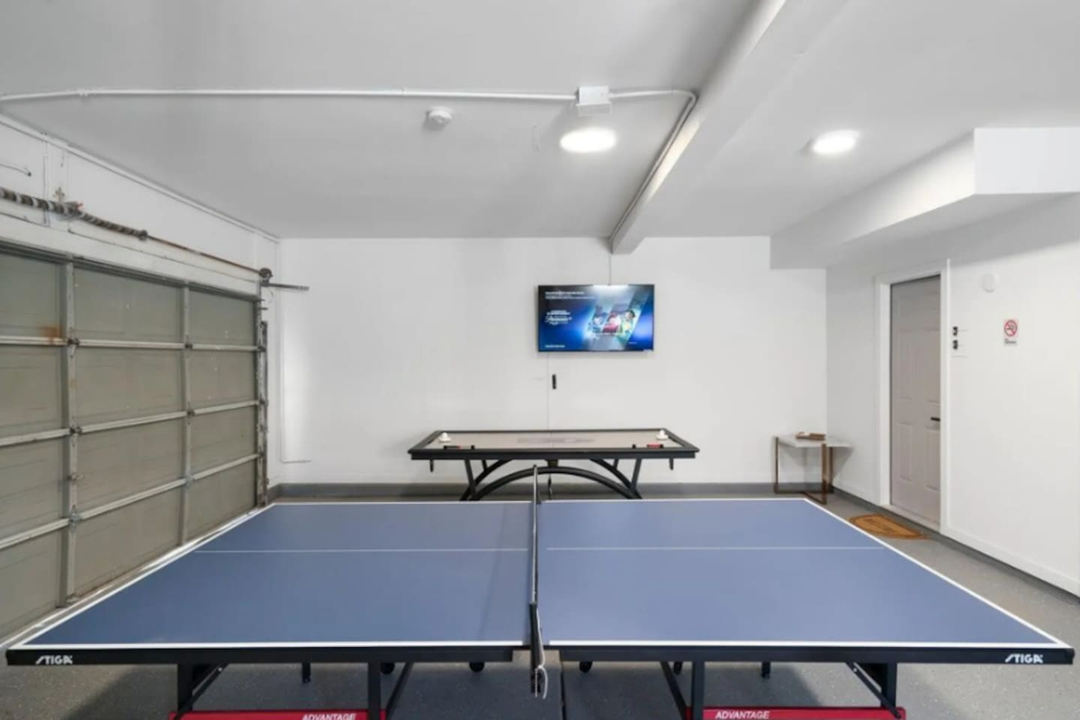 Recreation garage with professional ping pong and pool tables for indoor entertainment.