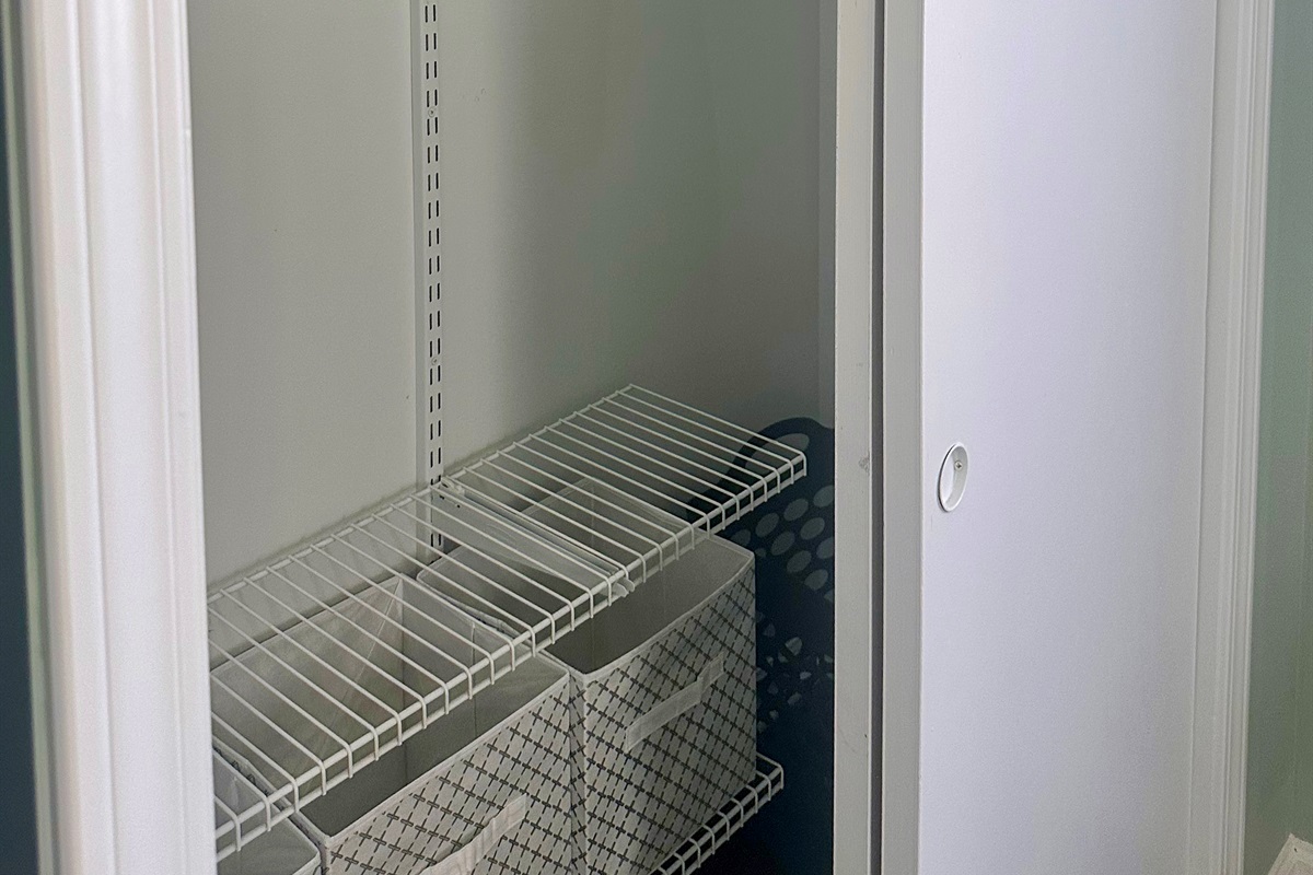 Primary bedroom closet with hanging space, shelving, and storage baskets. Designed to comfortably accommodate extended stays, allowing guests to fully unpack and settle in.