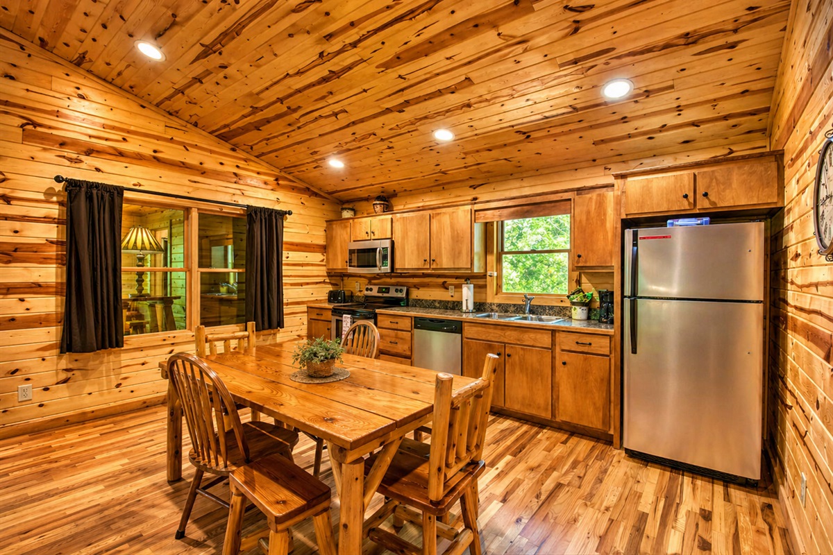 Cozy cabin dining meets a fully equipped kitchen—warm wood tones, vaulted ceilings, and the perfect space to gather, cook, and unwind.